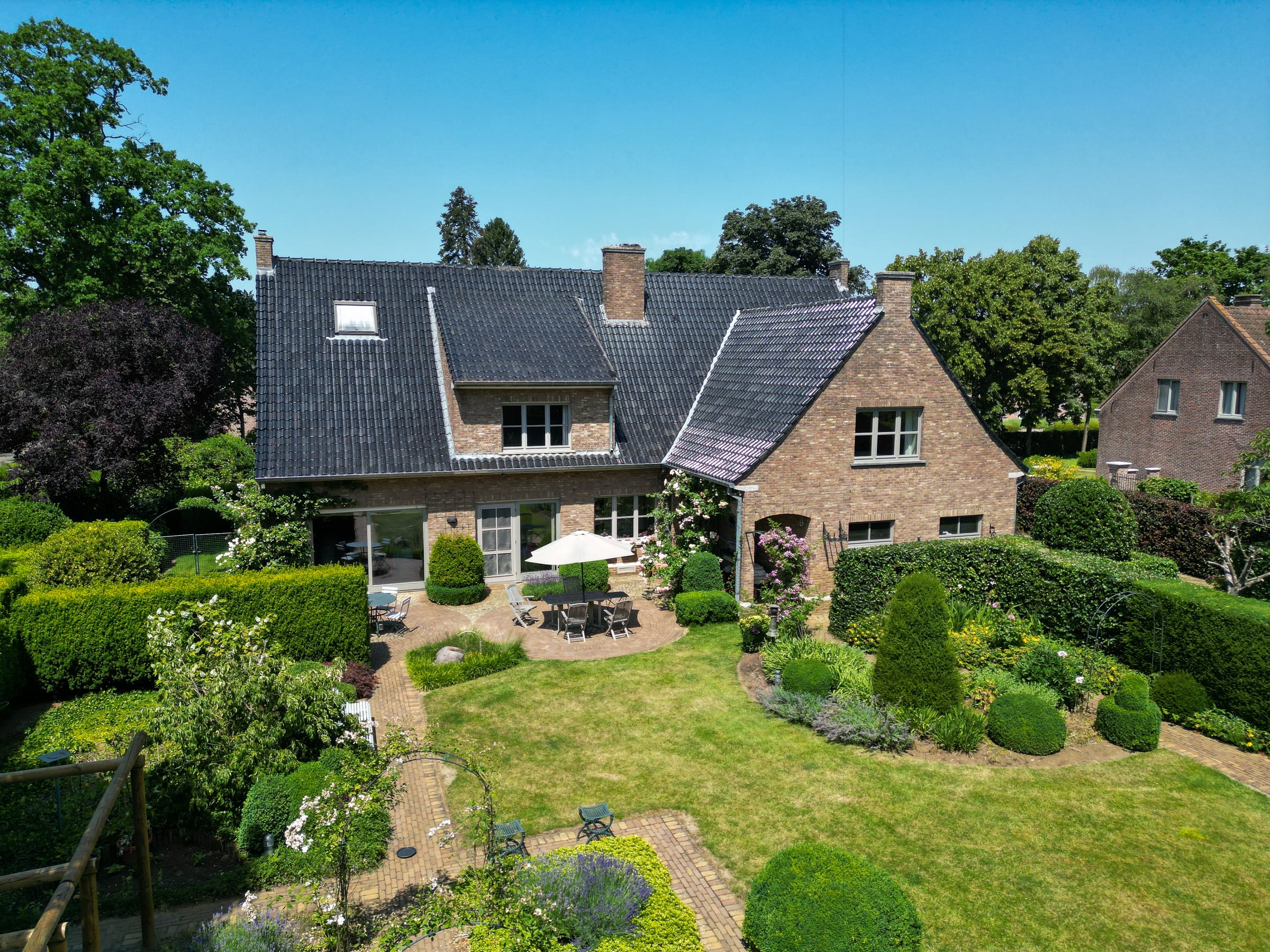 Dronebeeld van een moderne woning in een groene omgeving