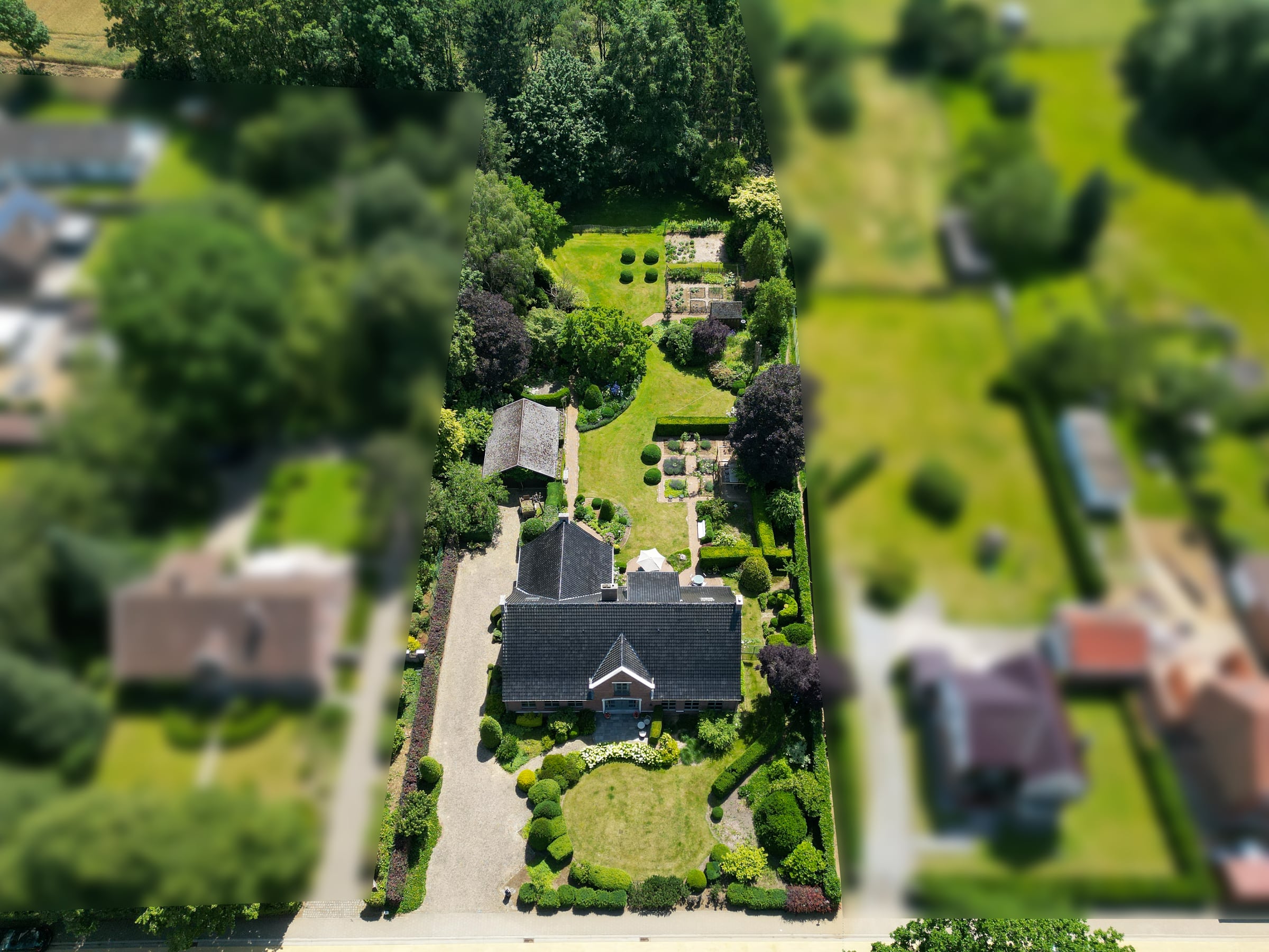Topdown dronebeeld van een woning en de omliggende tuin